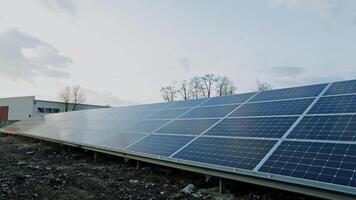 fotovoltaico solar painel às luz solar. grande azul ensolarado bateria em a campo gera limpar \ limpo energia. alternativo fonte do ecológico energia. video