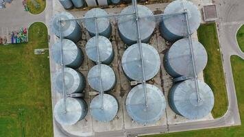 Large metal granaries. Agriculture manufacturing plant . Agriculture grain silos storage tank. Grain elevator on factory. Top aerial view. video
