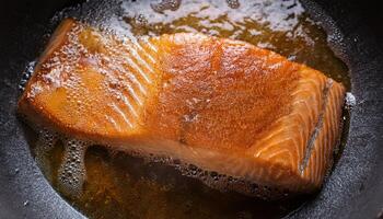 fresh salmon fillet sizzling in hot oil with crispy skin and golden textures forming during frying process photo