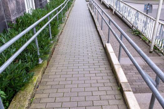 Empty ramp access for disabled people leading to grey building photo