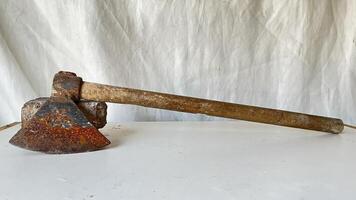 Rusty tool on a white surface showcasing its weathered condition photo
