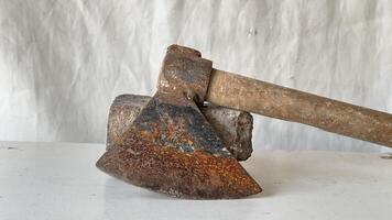 Rusty axe resting on a stone block in a workshop setting photo
