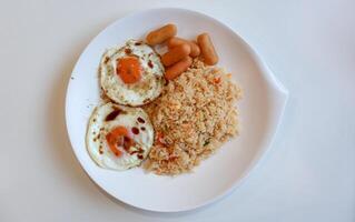 Top view of breakfast fried eggs with soy sauce and pepper, sausage, fried rice with egg photo