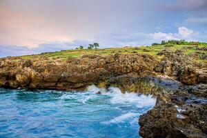 A view of the waves at the edge of the cliffs during sunset at Kelapa Satu Beach in Kupang, East Nusa Tenggara photo