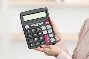Tour Agent Lady Showing Calculator With Price To Black Family Couple Offering Expensive Vacation Trip Sitting In Travel Agency Office, Wearing Face Masks. Selective Focus photo