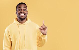 Great Idea. Excited African American Guy Pointing Finger Up Having Thought And Inspiration Posing Standing Over Yellow Studio Background. Eureka Moment And Enlightment Concept. Panorama photo