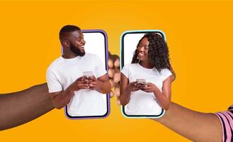 African American couple, each holding their smartphones, smiles at each other while chatting online. Their joyful interaction shows how technology keeps them connected, even from a distance. photo