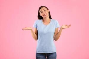 Excuse Me, I Don't Know. Portrait Of Clueless Young Woman Shrugging Shoulders, Spreading Hands, Looking At Camera Posing Over Yellow Studio Background. Studio Shot. Sorry, I Can't Tell photo