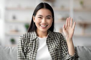 Positive asian lady having online party with boyfriend or family, job interview, using telecommunication application or software at home, cheerfully waving at camera, copy space, pov screen photo
