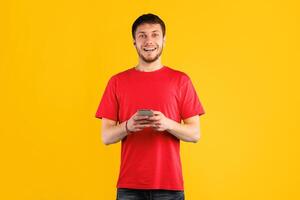 Surprised positive man using smartphone device, chatting online, typing sms, glad to recieve many messages of congratulation on mailbox, looking overjoyed at camera, connected to wireless internet photo