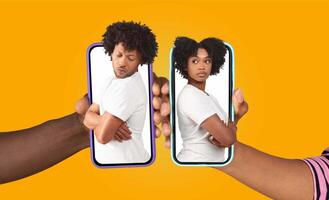 African American couple is seen using their smartphones to communicate. They display different emotions as they engage in a digital conversation. photo