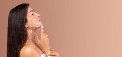 A lady is applying skin care products on her face, focusing on a relaxing beauty routine. She is in a tranquil setting with soft, neutral tones, creating a peaceful atmosphere for pampering. photo