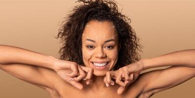 African American woman smiles while pampering herself with a skincare routine. She is in an isolated environment with a solid background, enjoying a moment of self-care and relaxation. photo
