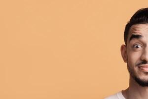 Portrait Of Surprised Young Middle Eastern Man Looking At Camera With Wide Open Eyes, Amazed Arab Guy Emotionally Reacting To News Or Offer, Posing Isolated Over Yellow Background, Copy Space photo