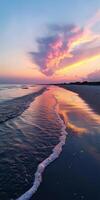 A beautiful sunset over the ocean with a wave in the water photo
