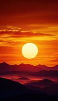 A large sun is setting over a mountain range photo