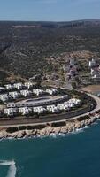 Aerial view of white holiday homes with sea and mountain views video