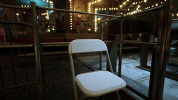 Lonely chair in an empty amusement park at night under dim lights video