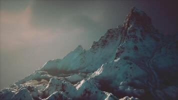 Majestic snow capped mountains under a dramatic sky at dusk in winter video