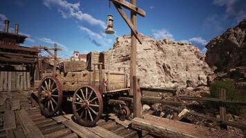 Old wooden cart near rustic wooden structures against a rocky backdrop video
