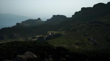 A view of a rocky mountain with a few animals on it. mountain path video