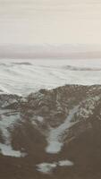 large snow patch left over on the volcanic rock field of a mountain in summer video