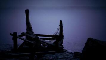 Fishing net structure at dusk by the water in a serene landscape video