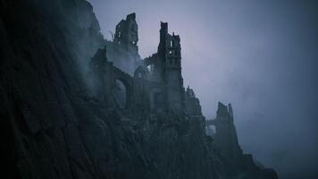Old castle ruins shrouded in mist on a rocky cliff at dusk video
