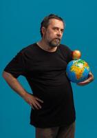 Man holding a globe and apple symbolizes global awareness through a creative perspective photo