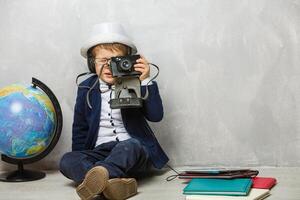 little photographer, boy with camera, stylishly dressed child in a waistcoat with a tie takes pictures on a digital camera photo