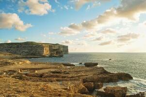 A seascape with cliff called Fungus Rock near the Azure Window in a sunset, Gozo island, Malta photo
