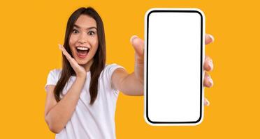 Wow, Amazing Useful App. Portrait of excited and surprised young woman holding smartphone with black blank screen in hand, showing device, closeup. Gadget with empty free space for mock up template photo