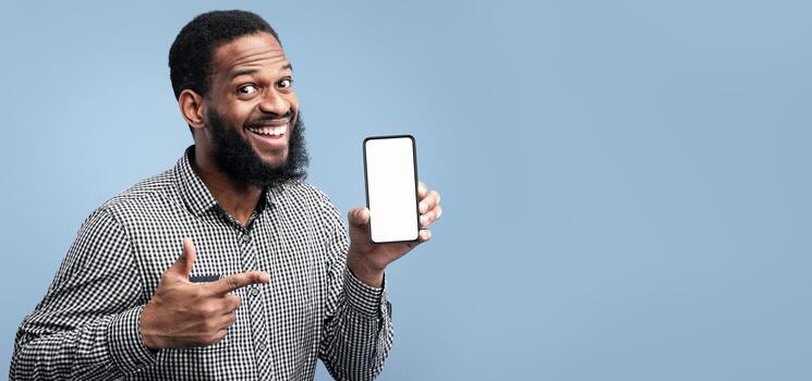 Useful App Or Website. Black man pointing at blank cell phone screen for advertising text, empty space, mock up photo