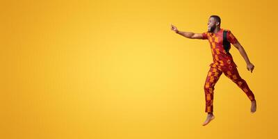 Excited black man in colorful authentic costume running towards copy space for advertisement, yellow background photo