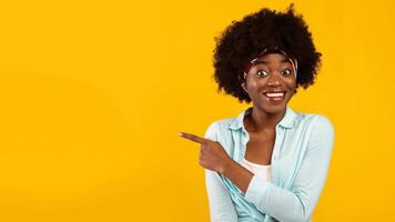 Look There. Smiling African American Woman Pointing Finger Aside Showing Empty Space Advertising Your Text Standing Over Pink Background In Studio. Advertisement Banner. Panorama photo