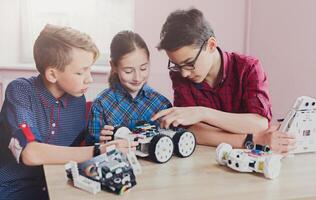 Children creating robots at school, stem education, copy space. Early development, diy, innovation, modern technology concept photo