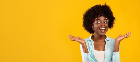 I Don't Know. Cheerful Black Lady Shrugging Shoulders Looking Aside At Copy Space Posing Standing Over Pink Background In Studio. African Woman Comparing Holding Invisible Objects On Hands. Panorama photo