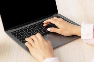 Over shoulder view of millennial housewife using personal computer with blank empty screen with copy space, typing on keyboard, brpwsing internet and looking for new healthy recipes online, mock up photo
