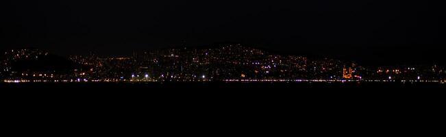 The skyline of Istanbul sparkles at night with countless lights reflecting photo