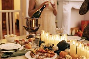 A close-up of an ice bucket and a bottle of champagne on a covered festive table. photo