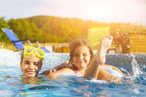 Children playing in pool. Two little girls having fun in the pool. photo
