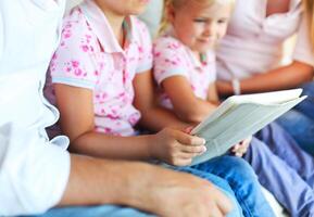 Happy family of mother, father and daughters using a tablet computer photo