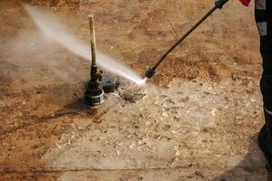 A man uses an electric pressure washer for a pressure washer. Cleaning city fountains in autumn. Workers remove the dirt that has settled photo