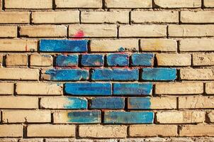 Texture of old colored bricks. Close-up of a red and green brick wall with painted bricks. Horizontal background with free space for text photo