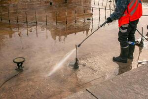man uses an electric pressure washer for a pressure washer. Cleaning city fountains in autumn. Workers remove the dirt that has settled during the season. photo