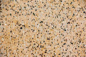 The texture of the stone wall. Abstract background with small multicolored stone particles. photo