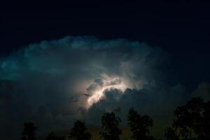 Night sky illuminated by a bolt of lightning during a thunderstorm in the Netherlands. photo
