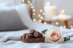 Chocolates on a satin pillow, a rose and fairy lights creating a romantic bedroom ambiance photo