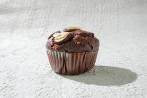 a chocolate muffin with nuts on top photo