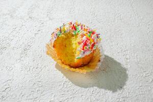 a cupcake with sprinkles on white background photo